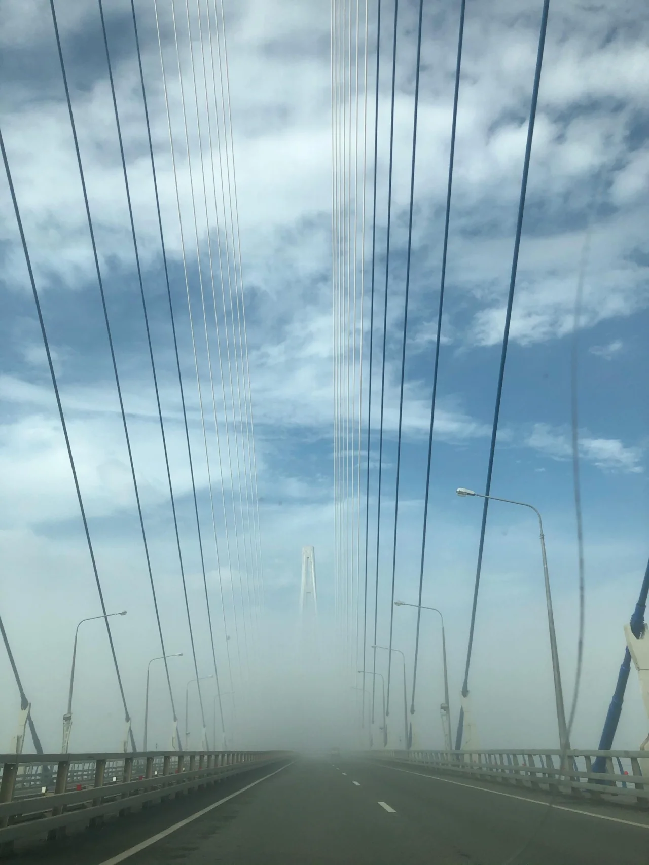Suspension bridge entering dense fog, illustrating pressure propagation and decision ambiguity.