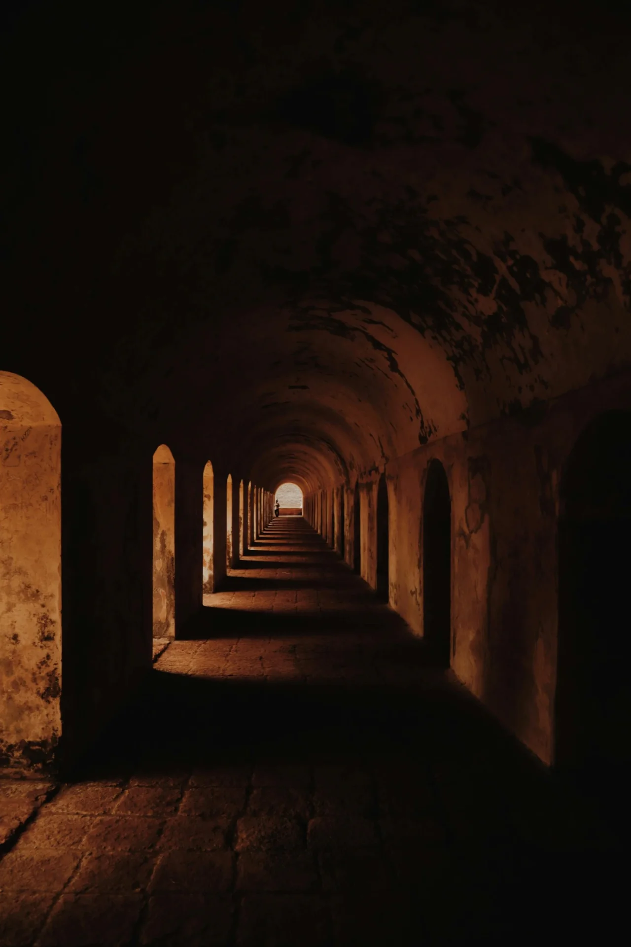 Long corridor of arches converging toward a vanishing point, symbolizing threshold geometry over time.